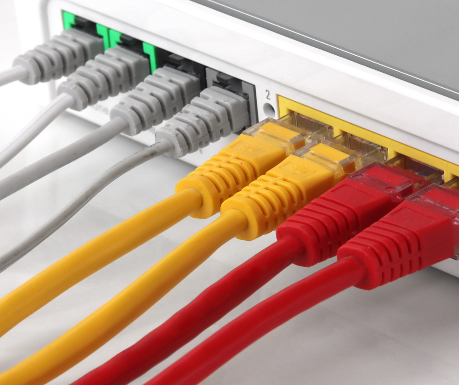 Close-up of network server racks with colorful Ethernet cables plugged into switches. Low voltage cables
