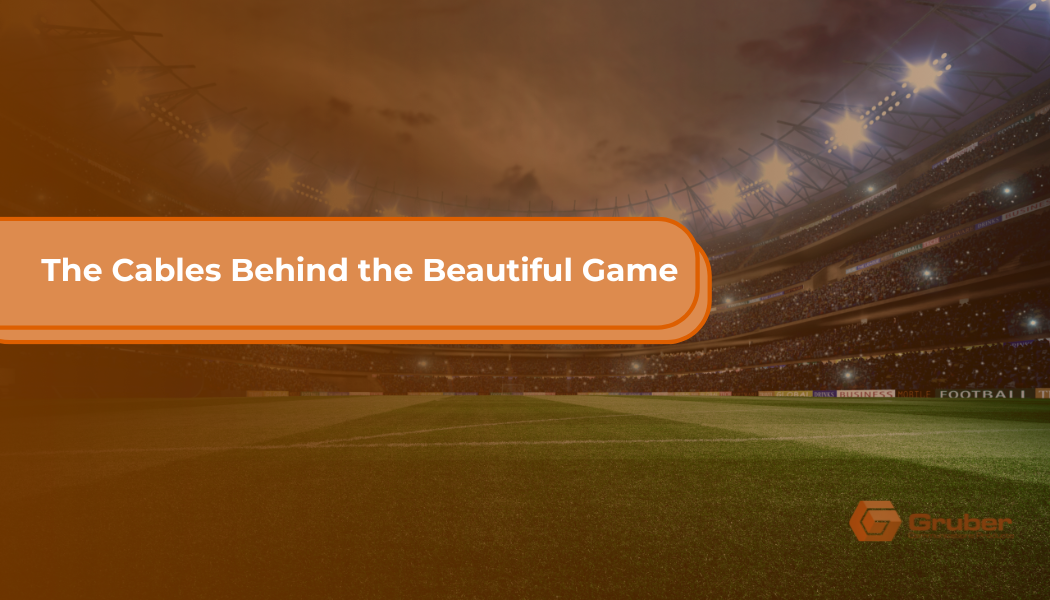A lit football stadium at dusk with an orange overlay, featuring the blog title 'The Cables Behind the Beautiful Game' — exploring how Ethernet cabling powers FIFA World Cup 2026 stadiums where stars like Lionel Messi, Kylian Mbappé, and Cristiano Ronaldo compete, with the Gruber logo in the bottom right corner.
